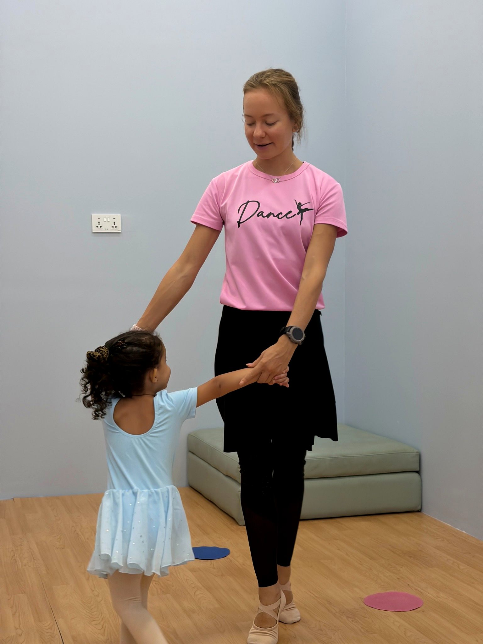 Ballet instructor guiding a child through dance steps