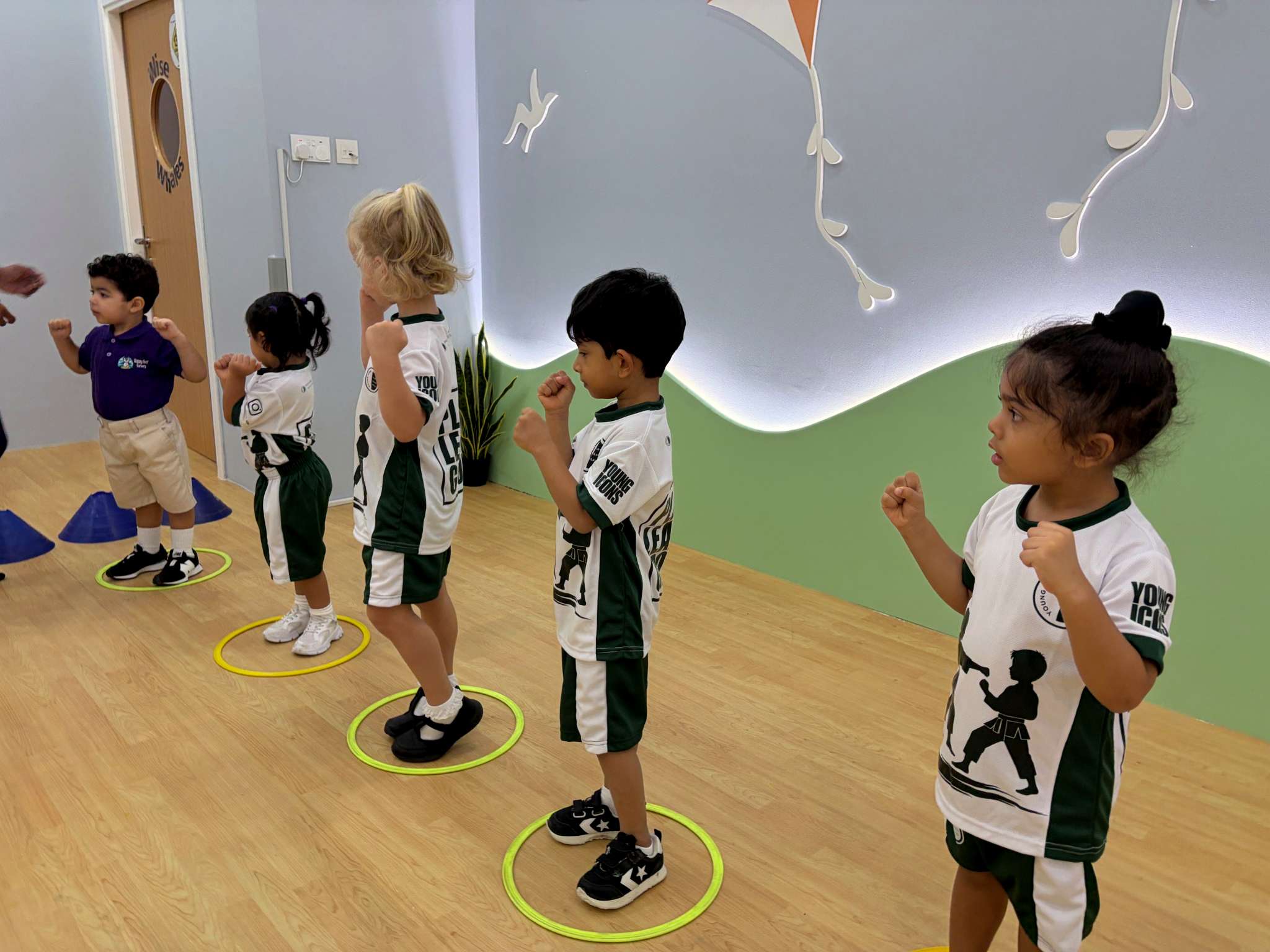 Children practising karate punches together during an instructor-led nursery lesson
